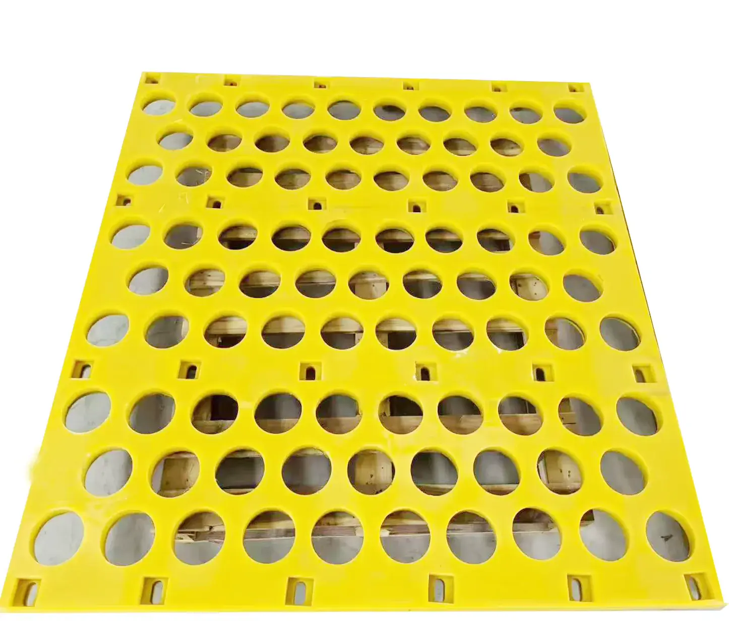 Yellow polyurethane panel with round apertures and fixing points.
