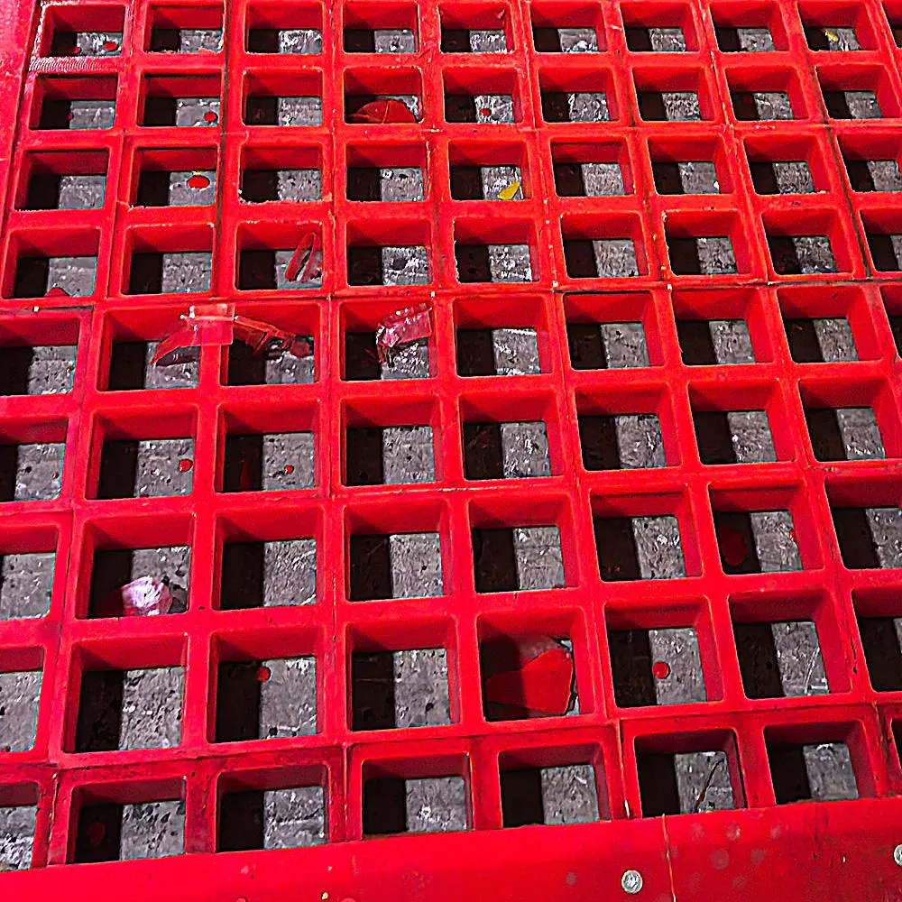 Close view of square apertures on a red tensioned polyurethane panel.