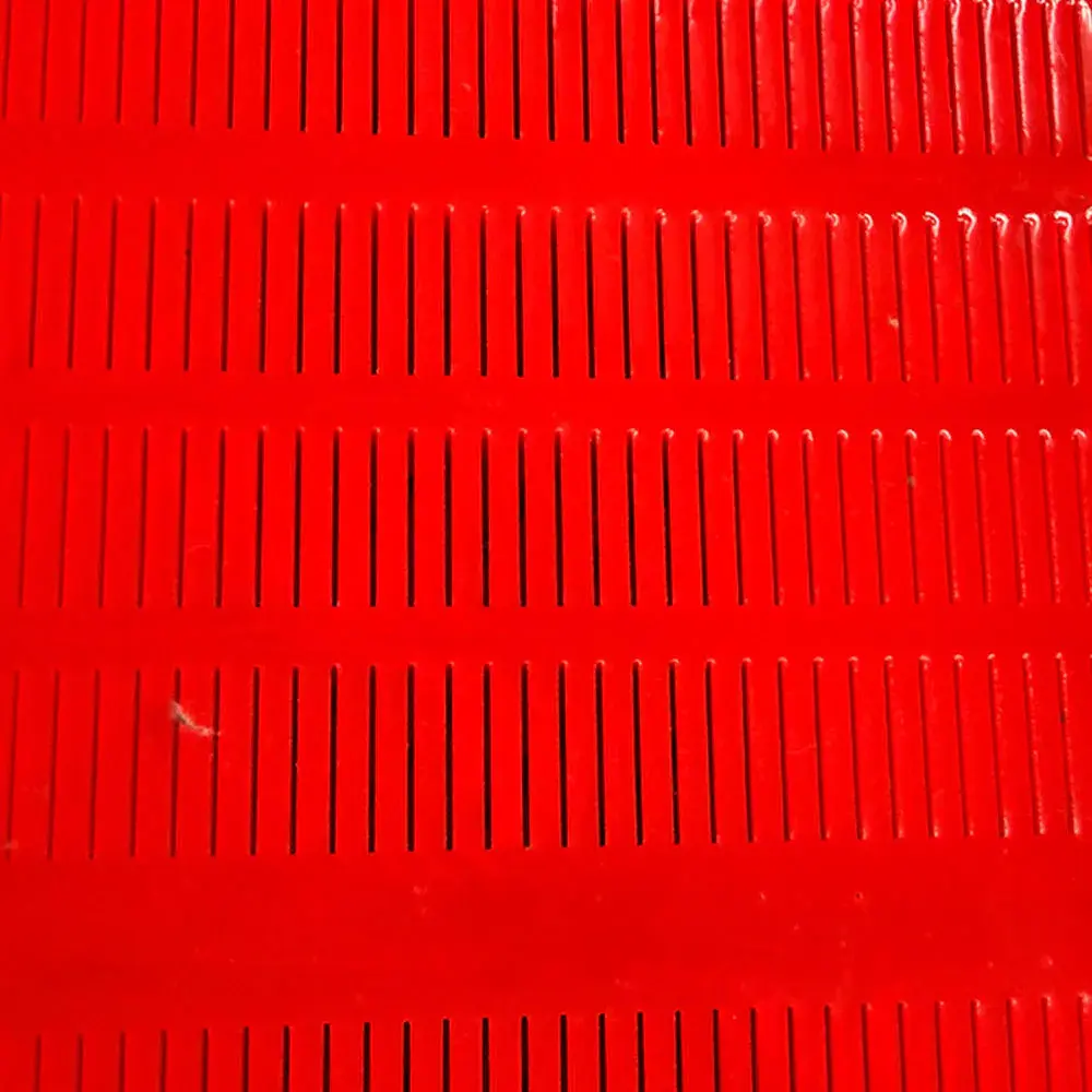 Close view of slot apertures in a red polyurethane dewatering screen panel.